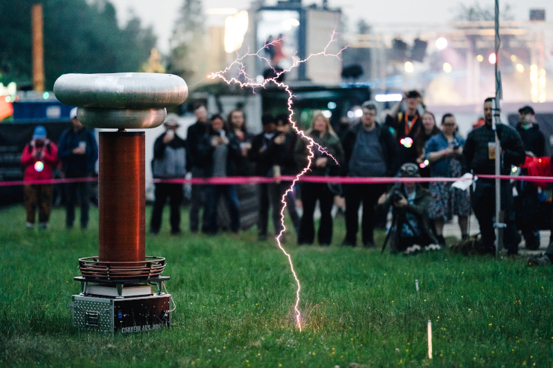Attendees watch a tesla coil produce music